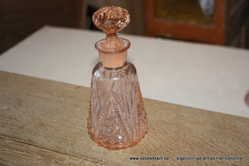 Antieke roze parfumflesje met geslepen dop.