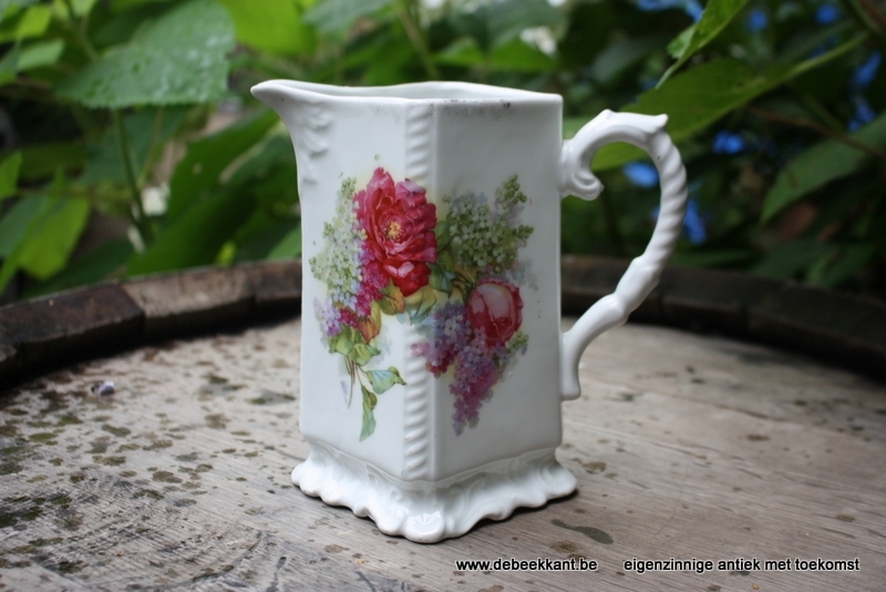 Antieke waterkan met bloemen